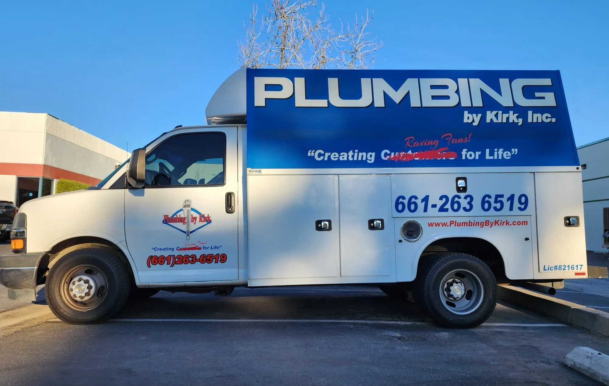 A Plumbing by Kirk box truck lettered with the company name, slogan and phone number