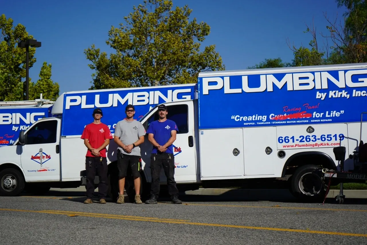 Three of Plumbing by Kirk's crew in front of the company's box trucks
