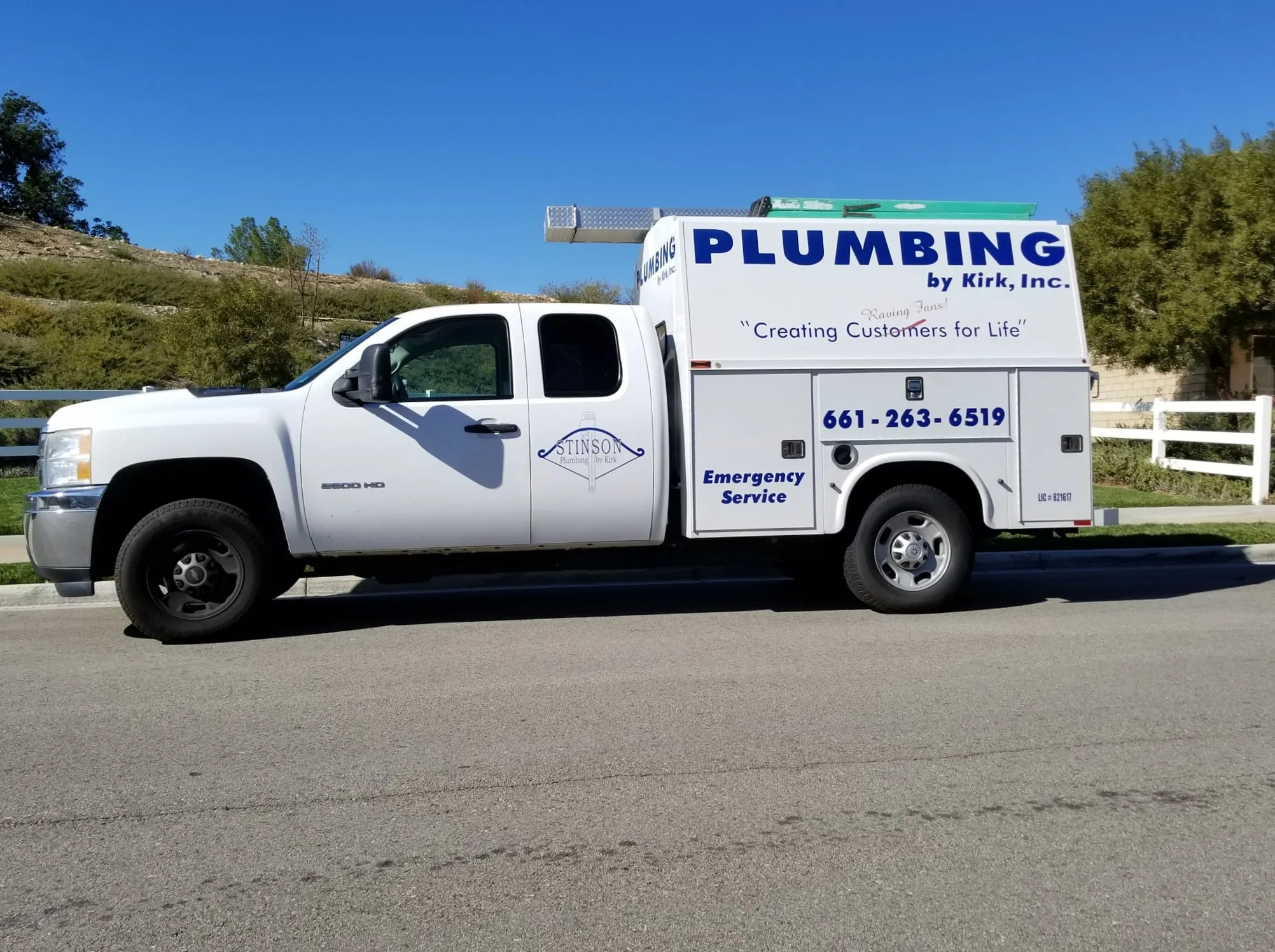 A Plumbing by Kirk pickup truck with a service body, parked on a residential street